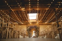 a bride walks down the aisle in a dark room with string lights