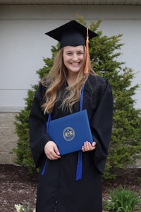 a young woman in a graduation gown holding a diploma