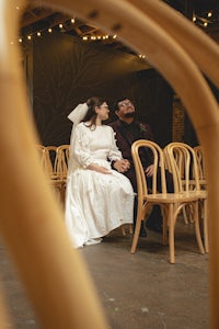 a bride and groom sitting in chairs