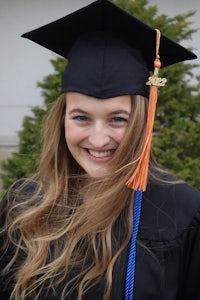 a young woman wearing a graduation gown and tassel