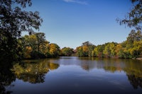 a lake surrounded by trees and a blue sky