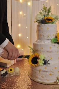 a wedding cake with sunflowers on it