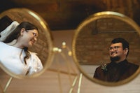 a bride and groom looking at themselves in a mirror