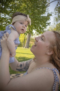 a woman holding a baby in the air