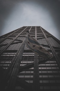 a flag flies from the top of a tall building