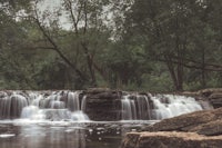 a waterfall in the middle of a wooded area