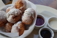 a white plate with donuts and sauce on it