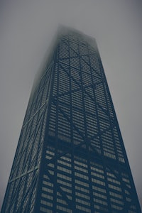 a tall skyscraper in a foggy day