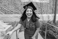 a black and white photo of a woman wearing a graduation cap